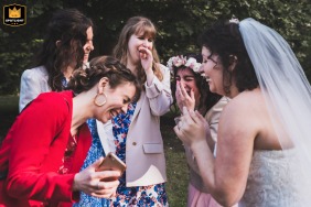 At Domaine du Bois Joli in Saint-Médard-en-Jalles, Gironde, the bride and guests burst into laughter while watching a video on a phone.